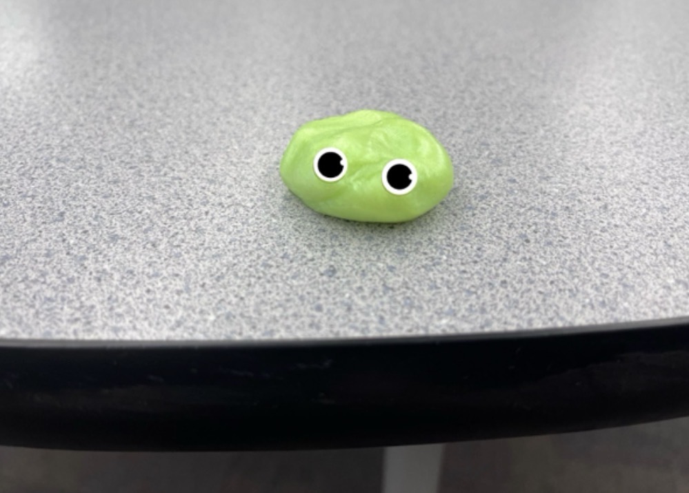 The new superintendent sits on a classroom desk. “See, we couldn’t possibly say no to that cute face,” said outgoing superintendent Caryn Gibson.