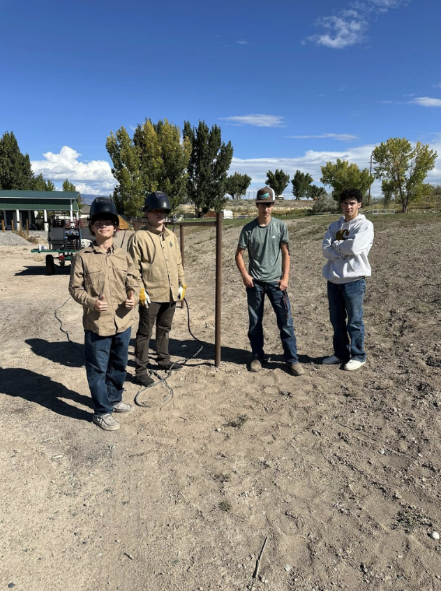 Brody Morfitt (far left) gives a thumbs up while working alongside classmates during a hands-on welding project, gaining real-world skills he plans to take with him to Texas after graduation.
